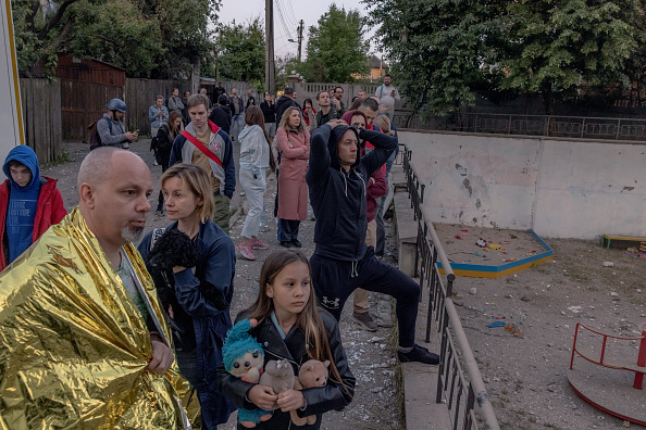 Des personnes devant un bâtiment résidentiel endommagé par des attaques de drones russes le 30 mai 2023 à Kiev, en Ukraine. (Roman Pilipey/Getty Images)