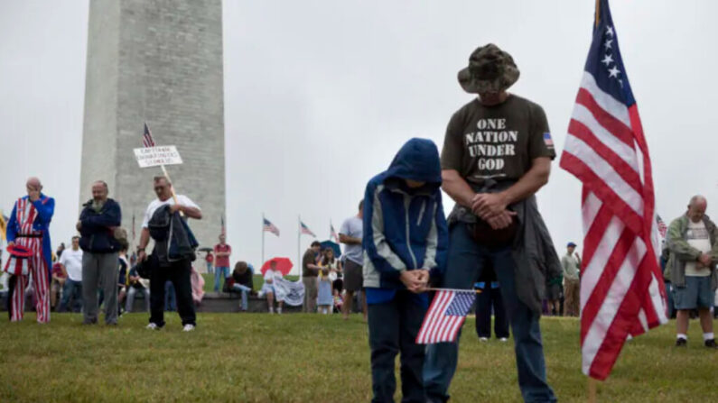 Des personnes s'inclinent pour prier lors d'un rassemblement sur le National Mall, près du Washington Monument, le 12 septembre 2010 à Washington, D.C. (Brendan Smialowski/Getty Images)