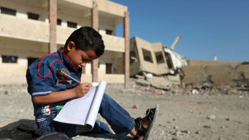 Un garçon yéménite assis à l'extérieur d'une école qui a été endommagée par une frappe aérienne dans la ville de Taez, dans le sud du Yémen, le 16 mars 2017. (Ahmad Al-Basha/AFP via Getty Images)