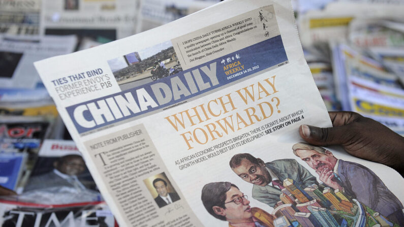 Un lecteur avec un exemplaire de l'édition africaine du quotidien chinois devant un kiosque à journaux dans la capitale kenyane, sur cette photo d'archive du 14 décembre 2012. (Tony Karumba/AFP via Getty Images)