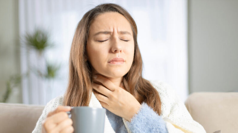 Jeune femme touchant le cou douloureux en raison d'un mal de gorge  causé par la grippe, le rhume ou une ilnfection. (Ahmet Misirligul/Shutterstock)