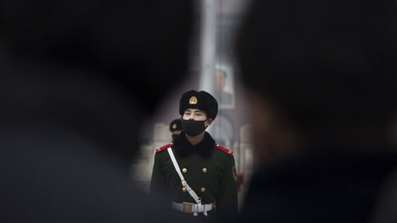 Un officier de la police paramilitaire chinoise porte un masque pour se protéger de la pollution, lors d'une marche sur la place Tiananmen à Pékin, le 9 décembre 2015. (Kevin Frayer/Getty Images)