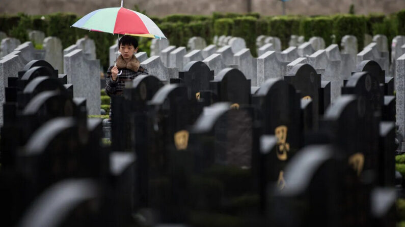 Un garçon se tient entre des tombes lors du festival annuel de Qingming, ou Journée de balayage des tombes, dans un cimetière public de Shanghai le 6 avril 2015. (Johannes Eisele/AFP/Getty Images)