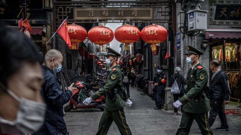 La police chinoise patrouille alors que les touristes se promènent dans une zone commerciale animée pendant le dernier jour des vacances de la Semaine d'or à Pékin, en Chine, le 8 octobre 2020. (Kevin Frayer/Getty Images)