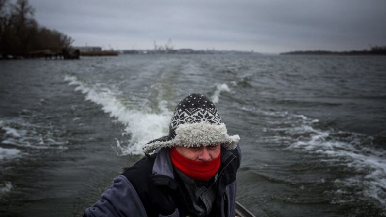 Oleksii Kovbassiouk, 47 ans, navigue sur son bateau alors qu'il s'apprête à évacuer les habitants d'un village de vacances sur l'île de Potyomkinskyi, sur le fleuve Dniepr, près de Kherson, le 6 décembre 2022, dans le contexte de l'invasion russe de l'Ukraine. (ANATOLII STEPANOV/AFP via Getty Images)