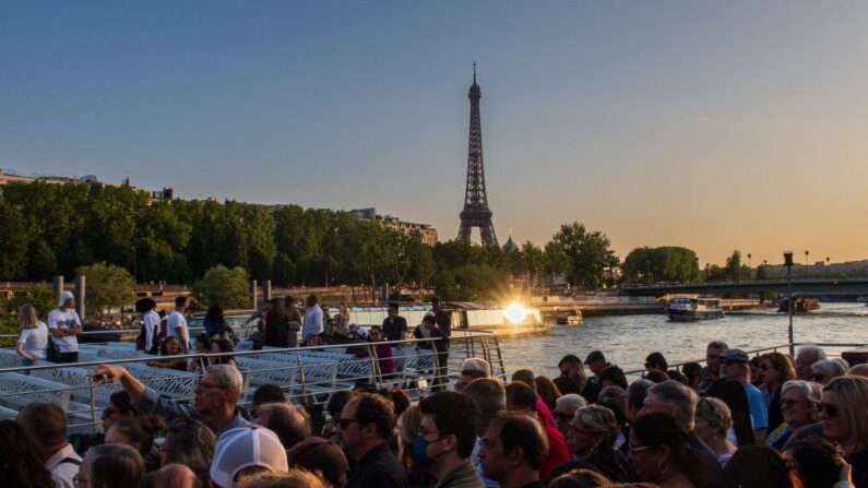 Photo prise le 27 mai 2023 montrant la tour Eiffel alors que des touristes sont assis sur une péniche parisienne sur la Seine. (Photo SAMEER AL-DOUMY/AFP via Getty Images)