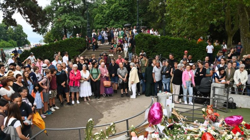 Des personnes se rassemblent pour déposer des fleurs à la mémoire des victimes de l'attaque au couteau survenue dans le parc des Jardins de l'Europe à Annecy. (Photo OLIVIER CHASSIGNOLE/AFP via Getty Images)