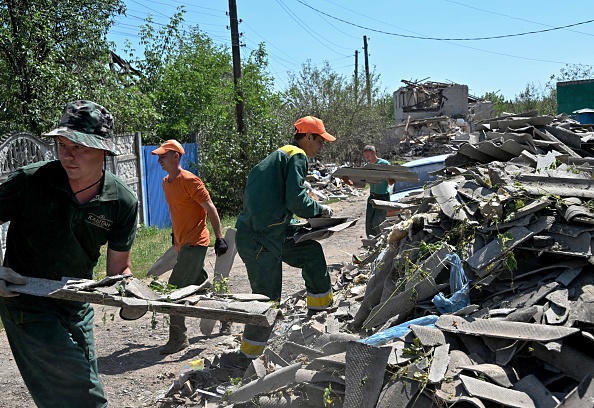 Des employés municipaux nettoient les débris des maisons détruites par une attaque de missiles russes, dans la ville de Kramatorsk, dans la région de Donetsk, le 19 juin 2023. (GENYA SAVILOV/AFP via Getty Images)