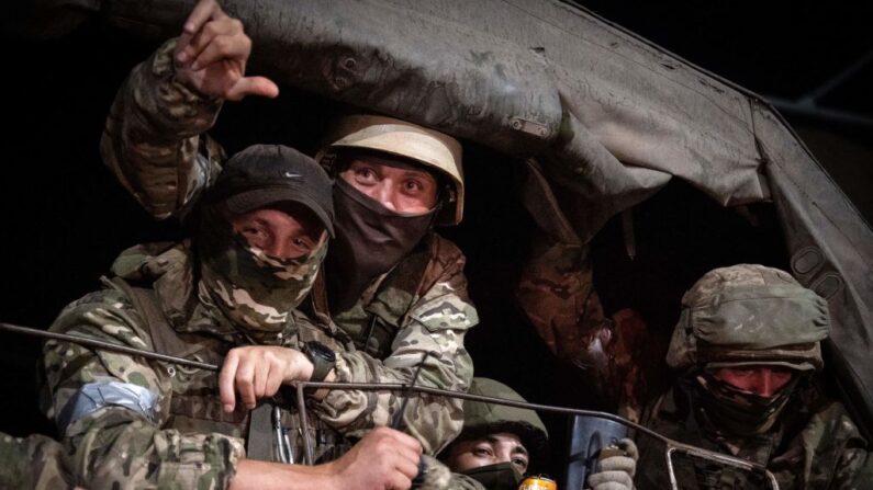 Des membres du groupe Wagner regardent depuis un véhicule militaire à Rostov-sur-le-Don, le 24 juin 2023. Le chef des mercenaires rebelles, Evgueni Prigojine, qui avait envoyé ses combattants renverser les chefs militaires à Moscou, va partir pour la Biélorussie et les poursuites pénales engagées contre lui seront abandonnées dans le cadre d'un accord visant à éviter une "effusion de sang", a déclaré le Kremlin le 24 juin. (Photo by Roman ROMOKHOV / AFP) (Photo by ROMAN ROMOKHOV/AFP via Getty Images)