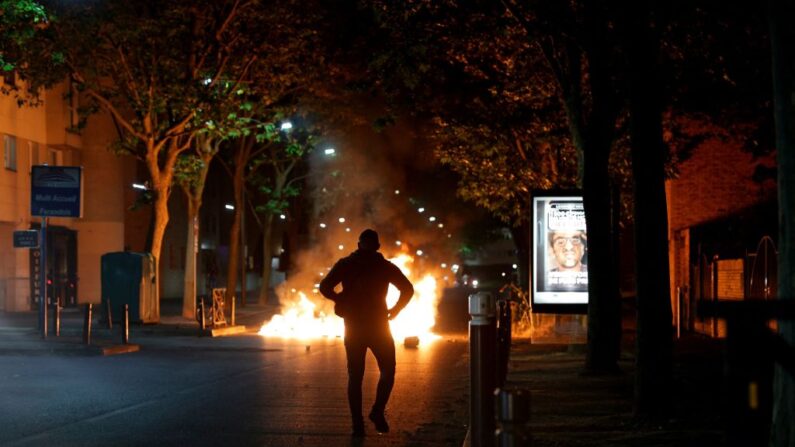 Un homme marche près d'un feu lors d'affrontements à Nanterre, le 28 juin 2023. (Photo: GEOFFROY VAN DER HASSELT/AFP via Getty Images)