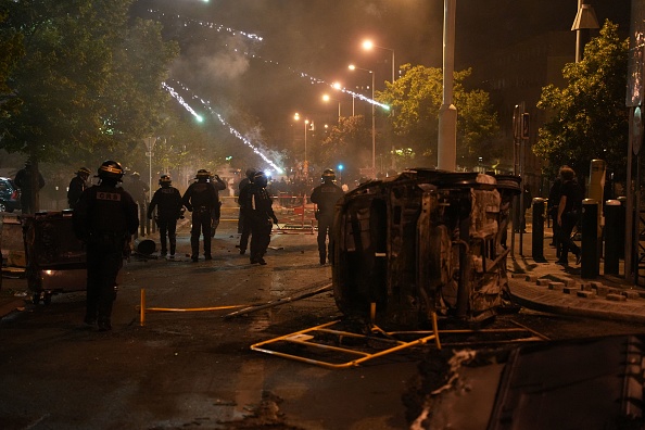 Des feux d'artifice explosent au-dessus des têtes de la police anti-émeute française lors de manifestations à Nanterre, à l'ouest de Paris, le 28 juin 2023.  (ZAKARIA ABDELKAFI/AFP via Getty Images)