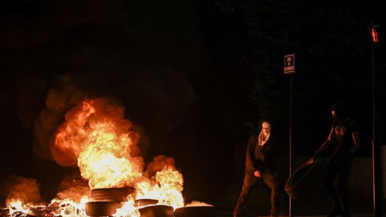 Des hommes jettent des pneus dans un feu, à Bordeaux, le 29 juin 2023. (Photo: PHILIPPE LOPEZ/AFP via Getty Images)