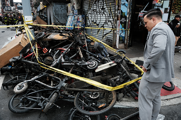 Des restes carbonisés de vélos électriques et de scooters sont exposés à l'extérieur d'un bâtiment dans le quartier chinois après que quatre personnes ont été tuées par un incendie dans un atelier de réparation de vélos électriques pendant la nuit du 20 juin 2023 à New York. (Photo : Spencer Platt/Getty Images)