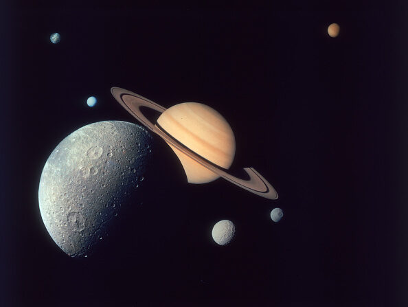 Montage de Saturne et de ses lunes Dioné (devant), Téthys et Mimas (à dr.), Encelade et Rhéa (à g.), et Titan (au loin, en haut), tel que représenté par la sonde Voyager 1, en novembre 1980. (Space Frontiers/Hulton Archive/Getty Images)