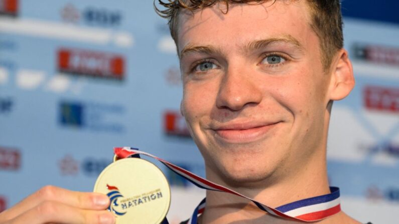 Léon Marchand, médaillé d'or au 200 m brasse, montre sa médaille lors des championnats de France de natation à Rennes, dans l'ouest de la France, le 11 juin 2023. (Photo by DAMIEN MEYER/AFP via Getty Images)