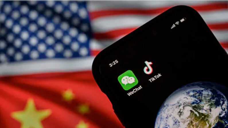 Sur cette photo d'illustration, un téléphone portable affiche les logos des applications chinoises WeChat et TikTok devant un écran montrant les drapeaux des États-Unis et de la Chine sur une page internet. (Kevin Frayer/Getty Images)