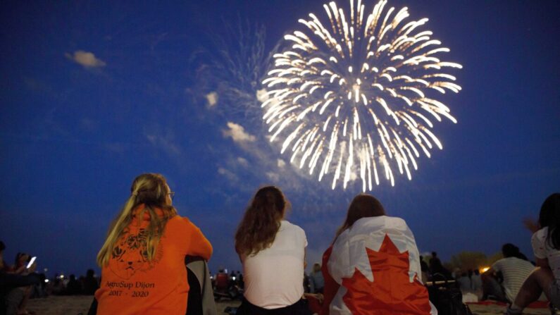 Les gens regardent les feux d'artifice au-dessus de la baie d'Ashbridges pendant les festivités de la fête du Canada à Toronto, le 1er juillet 2019. (Cole Burston/Getty Images)