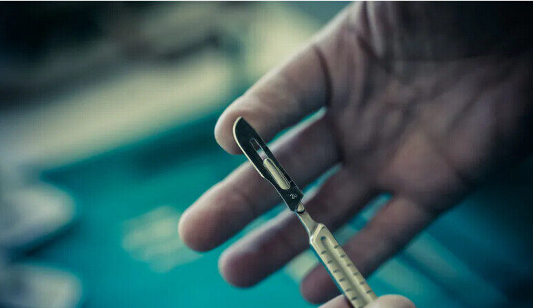 Un chirurgien tient un scalpel en métal. (Shutterstock)