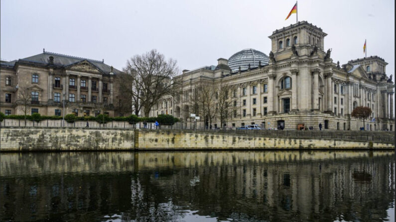 Le bâtiment du Reichstag (à dr.) qui abrite la chambre basse du Bundestag, et le complexe parlementaire Jakob-Kaiser-Haus (à g.) se reflètent dans la rivière Spree à Berlin, le 20 janvier 2023. (John MacDougall/AFP via Getty Images)