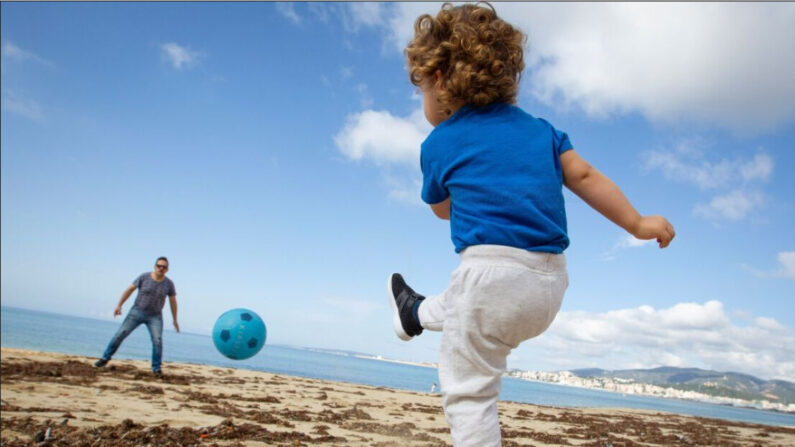 Un enfant joue au foot avec son père sur la plage de Palma de Majorque, en Espagne, le 26 avril 2020. (Jaime Reina/AFP via Getty Images)