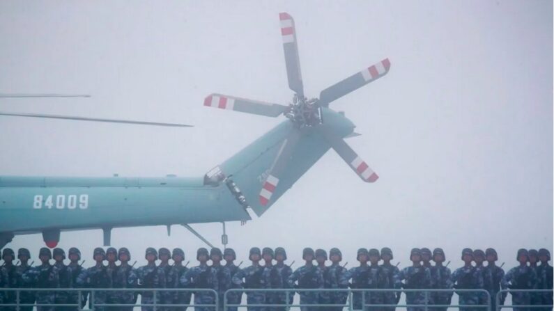 Des soldats se tiennent sur le pont de l'ambitieux dock de transport Yimen Shan de la marine de l'Armée populaire de libération (APL) chinoise, alors qu'il participe à une parade navale pour commémorer le 70e anniversaire de la fondation de la marine de l'APL chinoise en mer près de Qingdao, dans la province chinoise du Shandong (est), le 23 avril 2019. (Mark Schiefelbein/AFP via Getty Images)