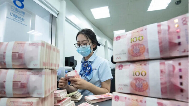 Un employé de banque compte des billets de 100 yuans au guichet d'une banque à Nantong, dans la province chinoise du Jiangsu, le 13 juin 2023. (STR/AFP via Getty Images)