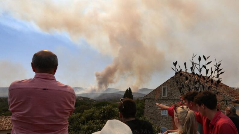 Des habitants du village de Grimaud, dans le département du Var, observent les feux de forêt qui font rage dans le sud-est de la France, le 17 août 2021. (Photo VALERY HACHE/AFP via Getty Images)