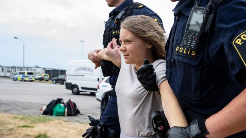 Des policiers emmènent l'activiste climatique suédoise Greta Thunberg avec d'autres activistes climatiques de l'organisation "Ta Tillbaka Framtiden" (Reprendre le futur), qui bloquent l'entrée du quartier d'Oljehamnen à Malmö, en Suède, le 19 juin 2023, pour le cinquième jour consécutif. (Photo JOHAN NILSSON/TT News Agency/AFP via Getty Images)