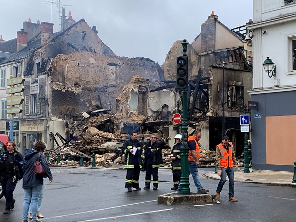 Le personnel d'urgence examine les lieux d'un bâtiment incendié - qui abritait une pharmacie - à Montargis, à quelque 100 km au sud de Paris, le 1er juillet 2023.   (MATHIEU RABECHAULT/AFP via Getty Images)