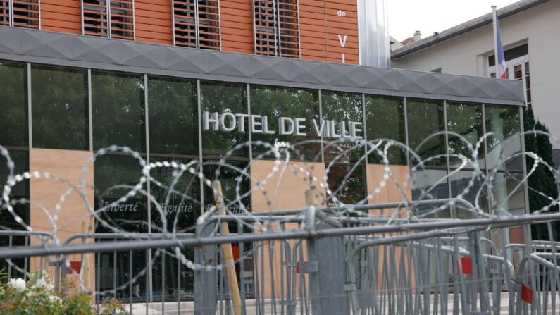 Cette photographie prise le 2 juillet 2023 montre des barbelés et des barrières devant la mairie de l'Haÿ-les-Roses, après une cinquième nuit de violences et d’émeutes nocturnes à travers la France (Photo GEOFFROY VAN DER HASSELT/AFP via Getty Images)