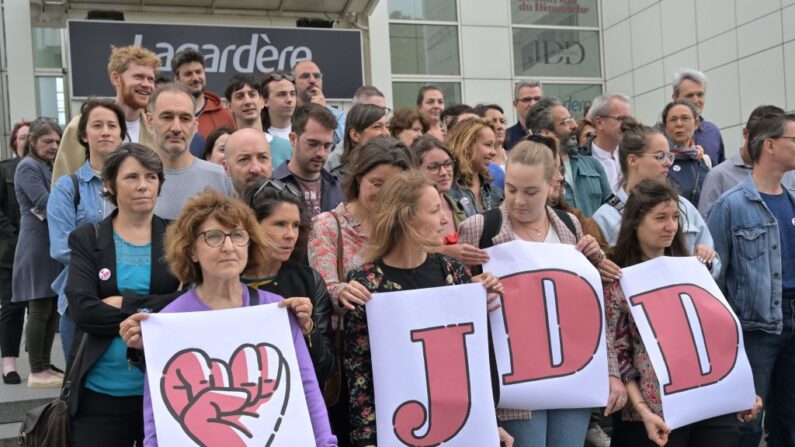 Les employés du Journal du Dimanche (JDD) se tiennent devant le bâtiment du JDD lors de leur 13ème jour de grève à Paris, le 5 juillet 2023. (Photo ALAIN JOCARD/AFP via Getty Images)