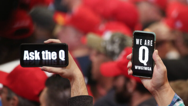 Des personnes brandissent des smartphones affichant des messages relatifs à QAnon lors d'un rassemblement à Las Vegas (Nevada), le 21 février 2020. (Mario Tama/Getty Images)