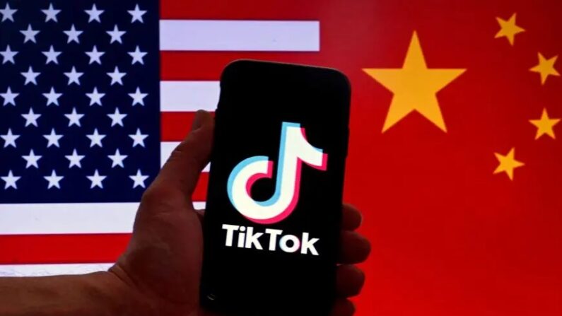 Le logo de l'application de média social TikTok sur l'écran d'un iPhone devant les drapeaux américain et chinois à Washington, le 16 mars 2023. (Olivier Douliery/AFP via Getty Images)