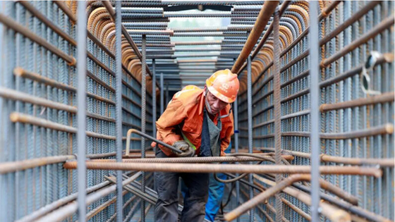 Un ouvrier prépare des barres d'acier sur le site de construction du pont Zhangjinggao du fleuve Yangtze sur l'île de Mazhou à Jingjiang, dans la province chinoise du Jiangsu (est), le 14 juillet 2023. (STRINGER/AFP via Getty Images)
