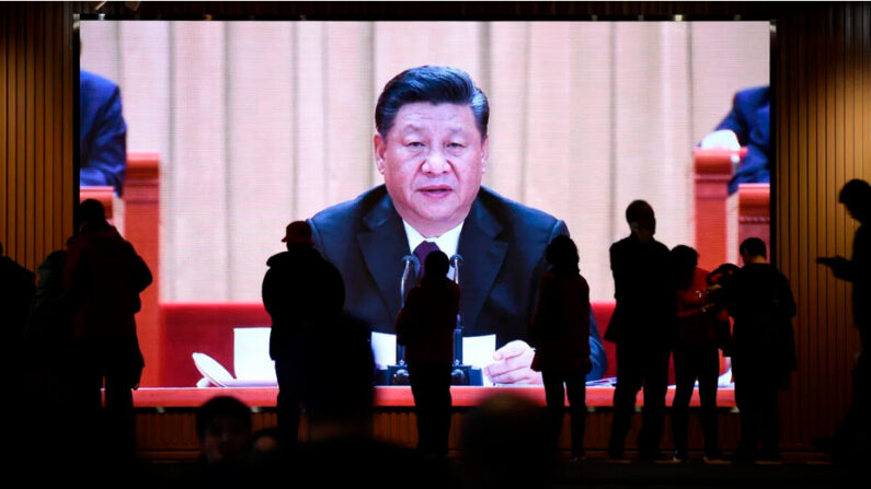 Des personnes passent devant un écran montrant des séquences vidéo du dirigeant chinois Xi Jinping au Musée national de Chine à Beijing, le 27 février 2019. (Wang Zhao/AFP via Getty Images)