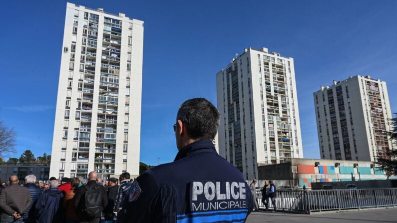 Un officier de police français devant des habitants du quartier  de Pissevin à Nîmes, qui manifestent le 21 février 2020, après une fusillade entre dealers et trafiquants de drogue à l'aide d'un fusil automatique Kalachnikov. (Photo PASCAL GUYOT/AFP via Getty Images)