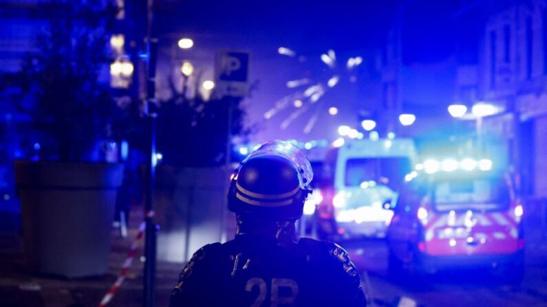 Des feux d'artifice éclatent alors que des policiers se tiennent prêts à intervenir lors d'émeutes à Roubaix, le 30 juin 2023. (Photo: KENZO TRIBOUILLARD/AFP via Getty Images)