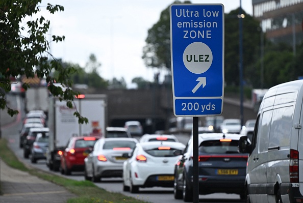 Des véhicules passent devant un panneau indiquant la zone à très faibles émissions (ULEZ) près de Hanger Lane, à Londres. (Photo JUSTIN TALLIS/AFP via Getty Images)