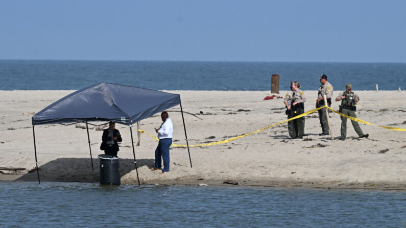 Des policiers se tiennent à côté d'un tonneau où un corps a été découvert à Malibu Lagoon State Beach, en Californie, le 31 juillet 2023. (Photo : ROBYN BECK/AFP via Getty Images)