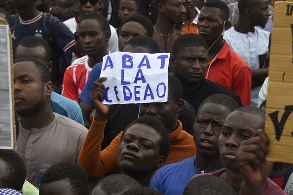 Des manifestants brandissent des pancartes dénonçant la Communauté économique des États de l'Afrique de l'Ouest (CEDEAO) à Niamey, le 3 août 2023. (Photo AFP via Getty Images)