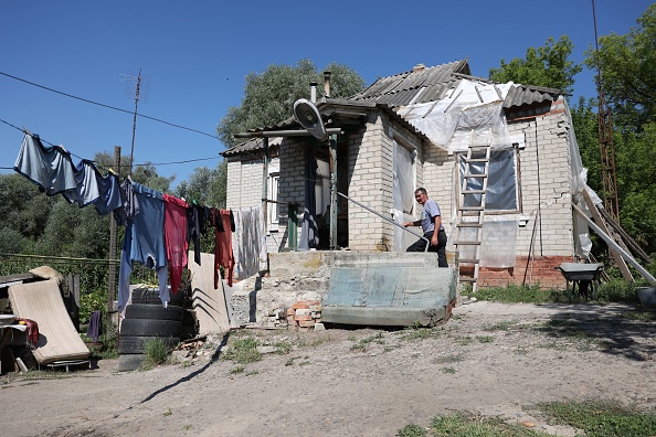 À l'extérieur d'une maison endommagée dans le village de Mala Komyshuvakha, à Kharkiv, le 8 août 2023, au milieu de l'invasion russe en Ukraine. (Photo : ANATOLII STEPANOV/AFP via Getty Images)