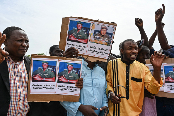 Un partisan du Conseil national pour la sauvegarde de la patrie (CNSP) du Niger brandit une pancarte avec la photo du général Abdourahamane Tiani à Niamey le 6 août 2023. (Photo AFP via Getty Images)