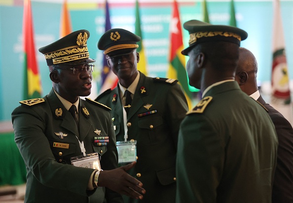Des membres des forces armées sénégalaises discutent en marge de la session des chefs d'État et de gouvernement de la Cedeao à Abuja, le 10 août 2023. (Photo KOLA SULAIMON/AFP via Getty Images)