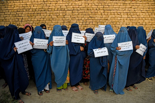 Des femmes afghanes vêtues d'une burqa tiennent des pancartes alors qu'elles manifestent pour leur droit à l'éducation, à Mazar-i-Sharif, le 12 août 2023. (Photo ATEF ARYAN/AFP via Getty Images)