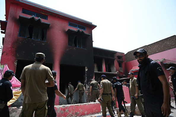 Des policiers inspectent une église de l'Armée du salut incendiée à Jaranwala, dans la banlieue de Faisalabad, le 17 août 2023. (Photo AAMIR QURESHI/AFP via Getty Images)