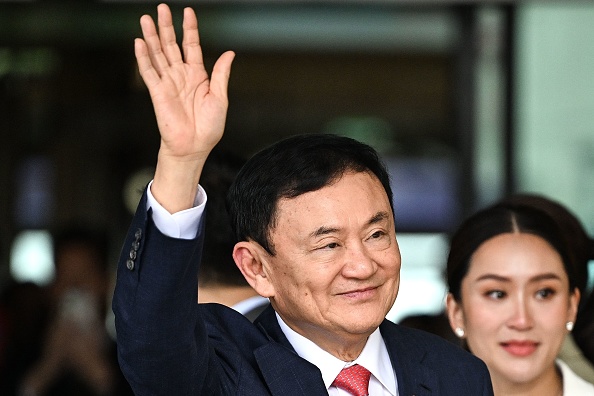 L'ancien Premier ministre thaïlandais Thaksin Shinawatra salue ses partisans à l'aéroport Don Mueang de Bangkok, le 22 août 2023. (Photo MANAN VATSYAYANA/AFP via Getty Images)