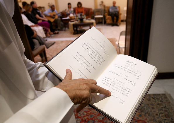 Un adhérent koweïtien à la foi bahaïe lit le livre sacré « Al-Kitab al-Aqdas » lors d'une séance de culte. (Photo STRINGER/AFP via Getty Images)