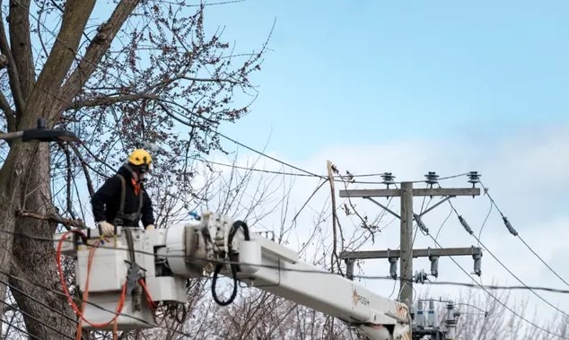 Des employés d'Hydro-Québec travaillent sur des lignes électriques à Montréal, le 7 avril 2023 (Andrej Ivanov/AFP via Getty Images)

