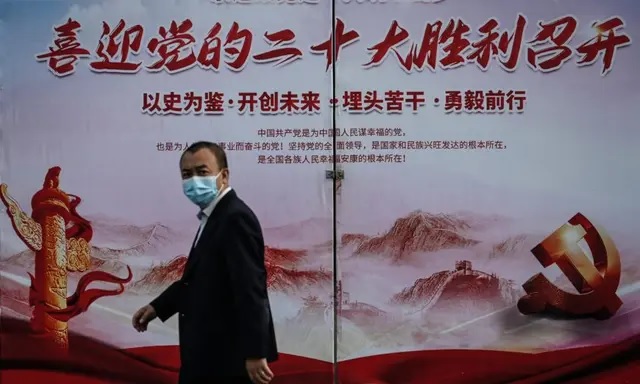 Un homme passe devant une affiche de propagande annonçant la réunion du 20e Congrès du Parti communiste, dans une rue de Pékin, le 21 septembre 2022. (Jade Gao/AFP via Getty Images)