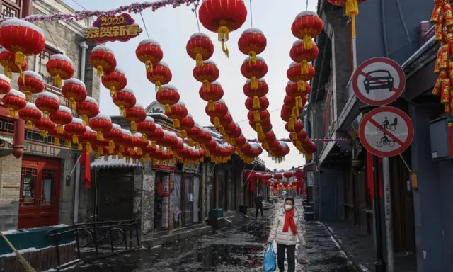 Une femme chinoise porte un masque de protection alors qu'elle marche dans une rue commerciale presque vide et fermée à Pékin, en Chine, le 7 février 2020. (Kevin Frayer/Getty Images)
